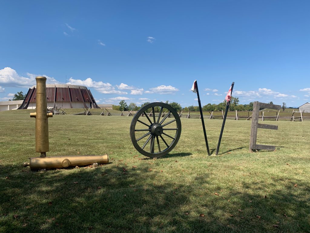 The word "Love" is spelled out using cannon barrels, a wagon wheel, a V made out of battle flags, and an E made out of fence boards.