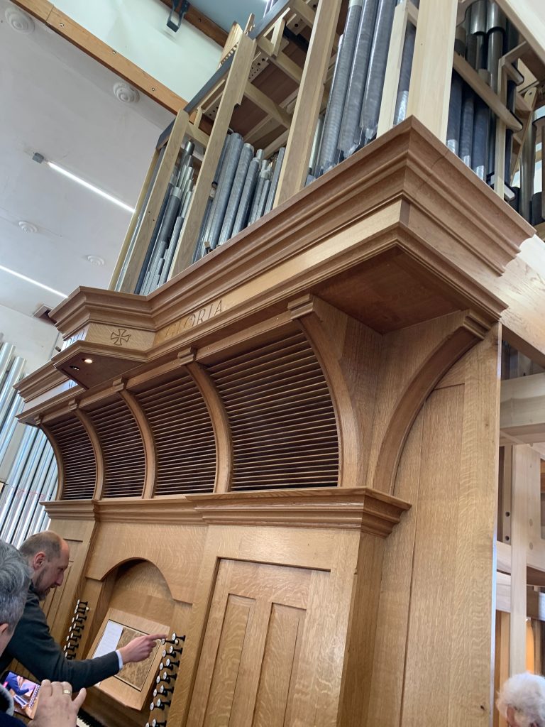 A large wooden pipe organ sits in temporary housing.